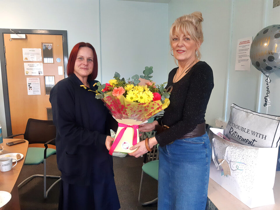Two people holding a bouquet of flowers