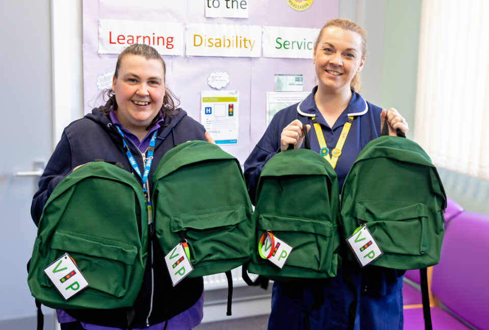 Smiling colleagues holding rucksacks