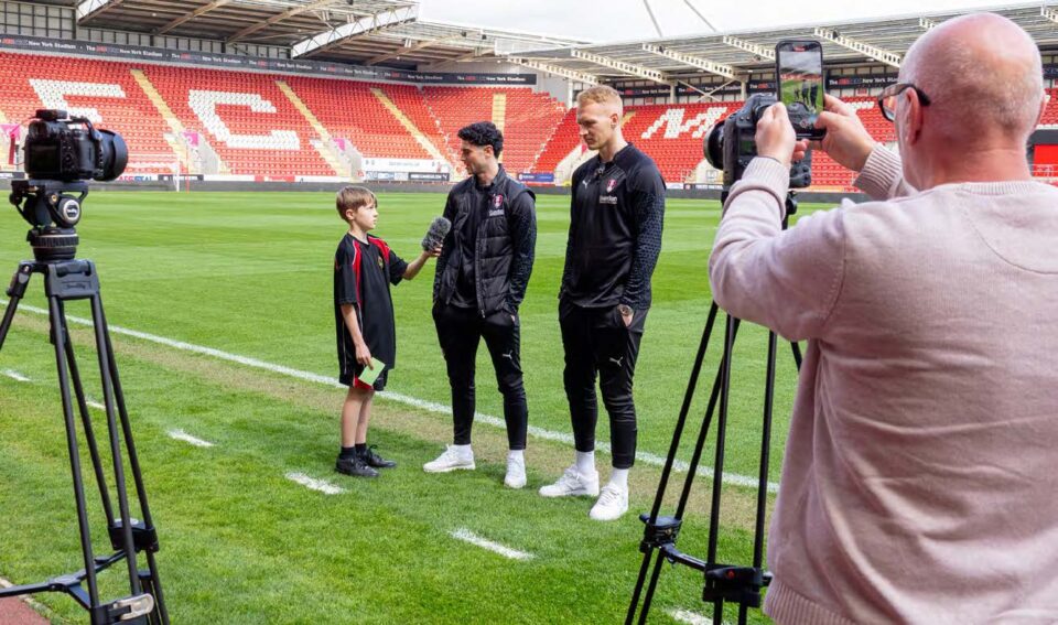 Student interviewing footballers