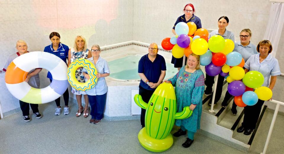 Ten people stood around a therapy pool