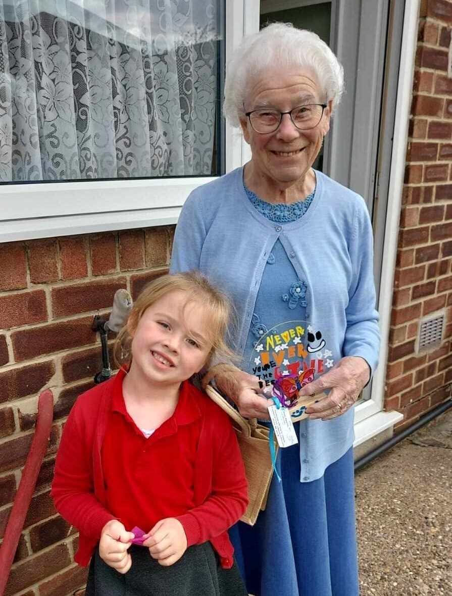 Woman smiling while holding a gift from a young club member