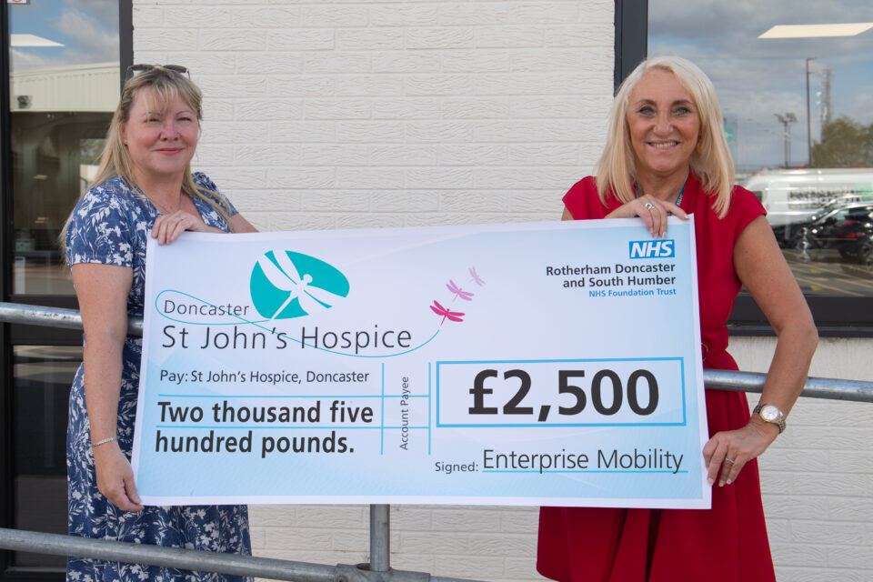 Two people holding a cheque for £2,500