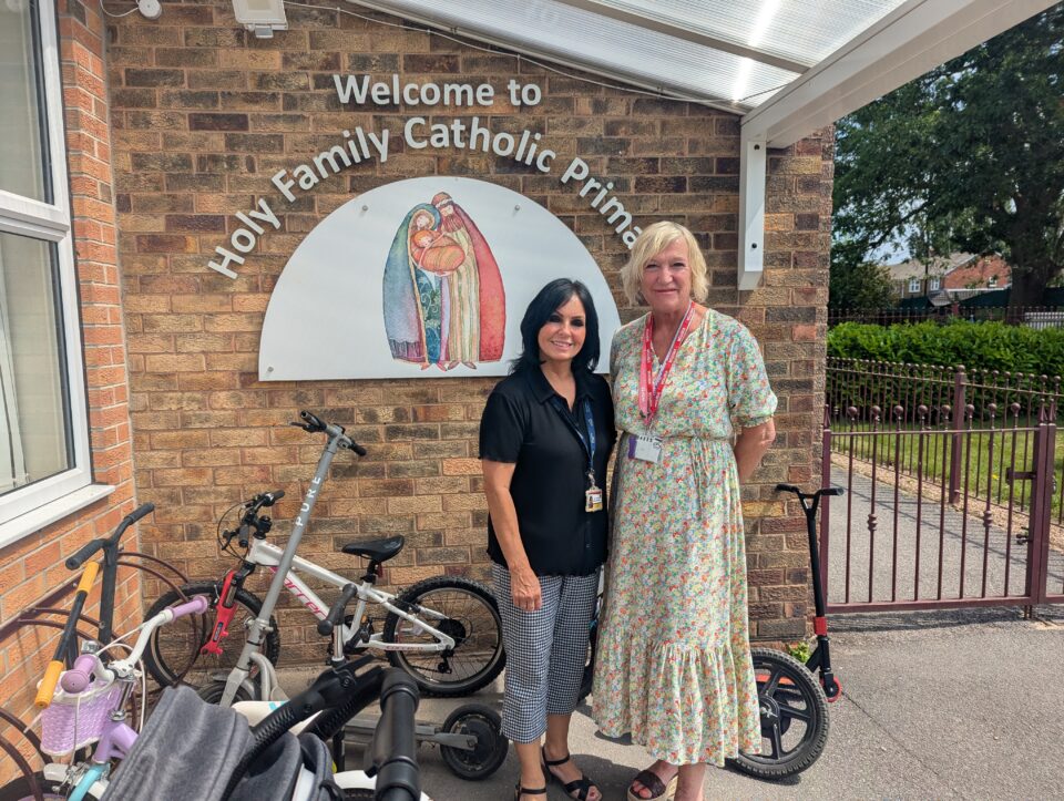 Two people in front of the Holy Family Catholic Primary School