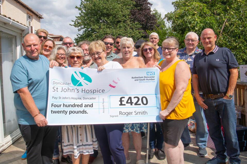 A group of people holding a cheque for £420