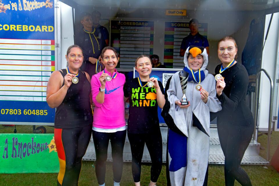 Five people holding up awards