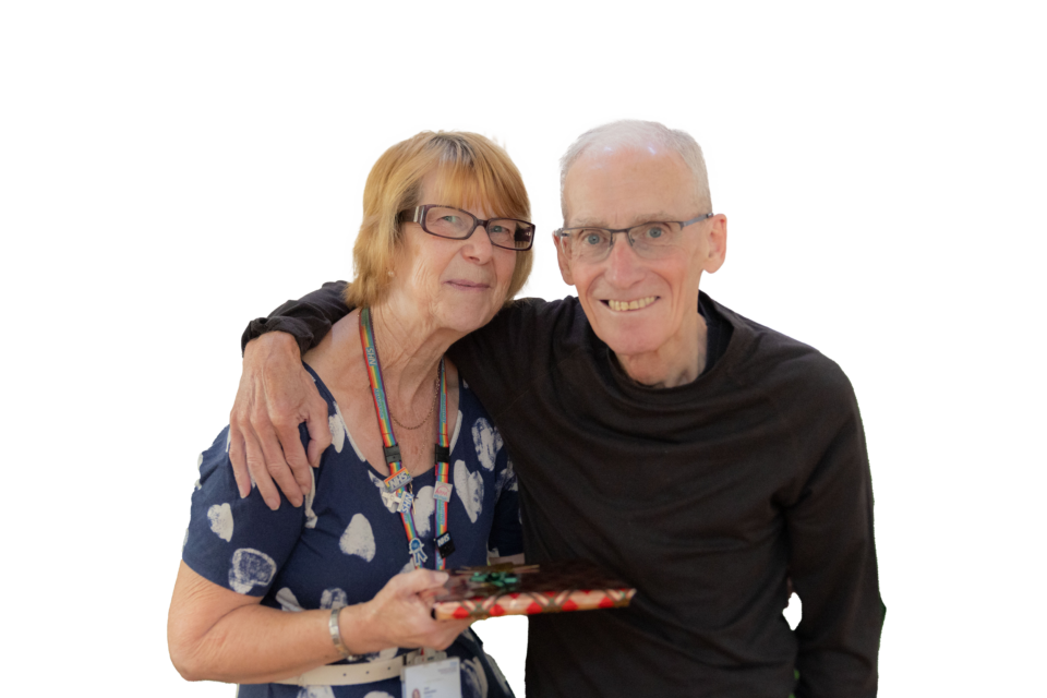 Man smiling with arm around woman