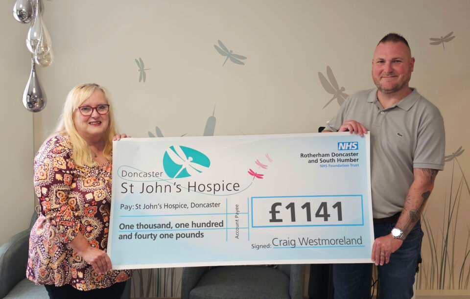 Craig Westmoreland and Ellie Watson holding up a £1,141 cheque